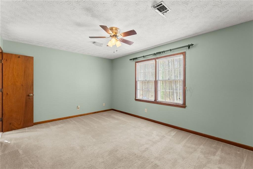 4691 Lucerne Valley Road Southwest Lilburn, GA 30047 - Photo 22 of 55 an empty room with windows and ceiling fan view