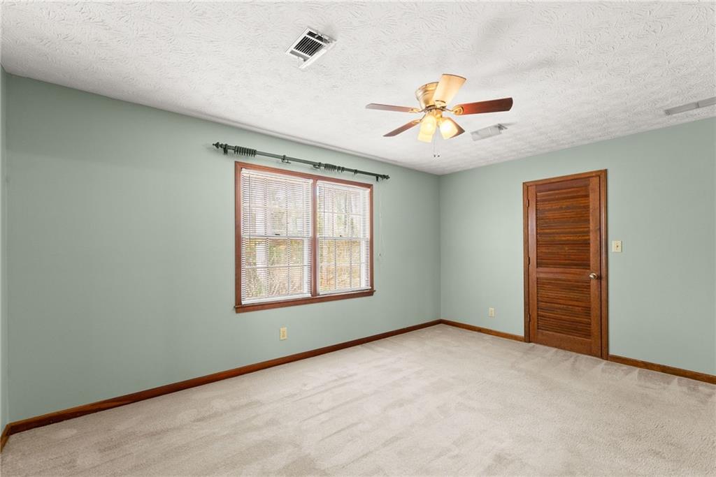 4691 Lucerne Valley Road Southwest Lilburn, GA 30047 - Photo 23 of 55 an empty room with windows and fan