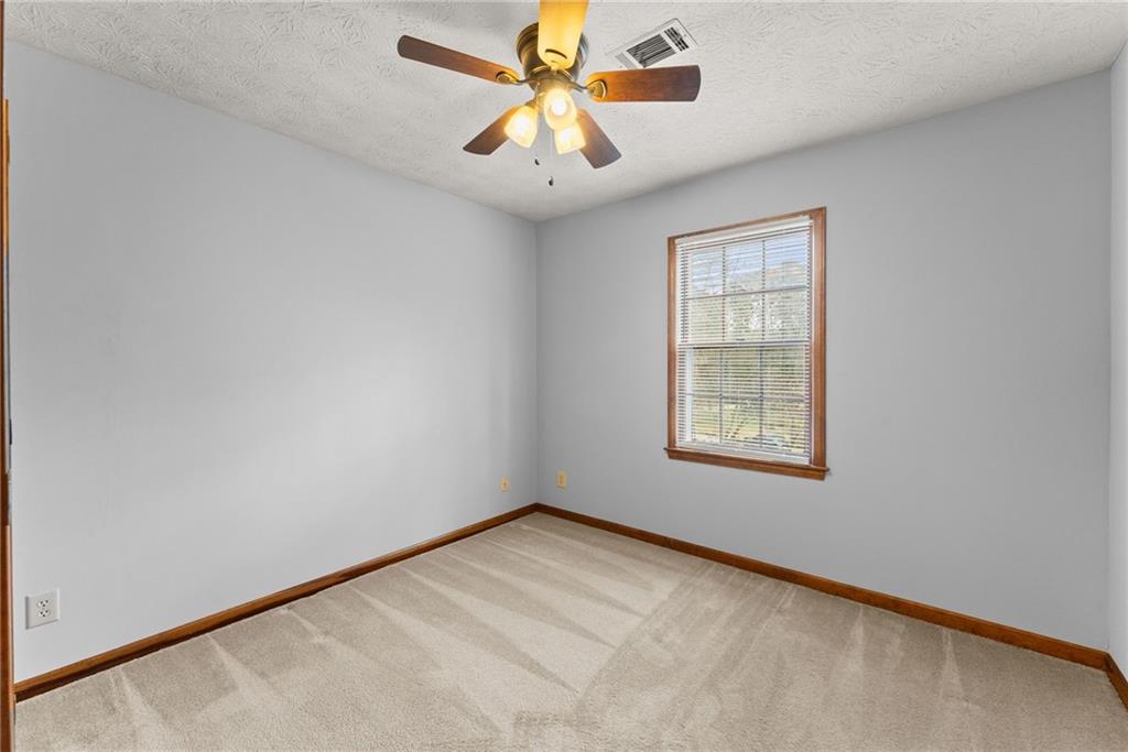 4691 Lucerne Valley Road Southwest Lilburn, GA 30047 - Photo 30 of 55 an empty room with windows and fan