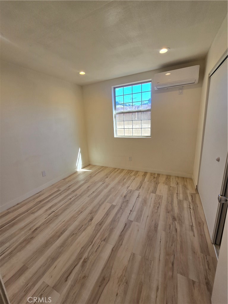3374 1/2 Fashion Avenue Long Beach, CA 90810 - Photo 6 of 11 an empty room with wooden floor and windows
