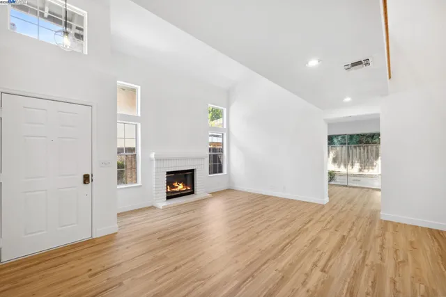 a view of a livingroom with wooden floor and a fireplace