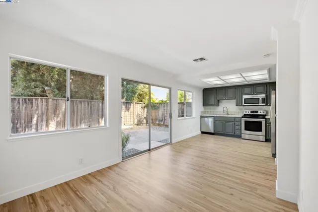a large kitchen with stainless steel appliances granite countertop a stove and a large window