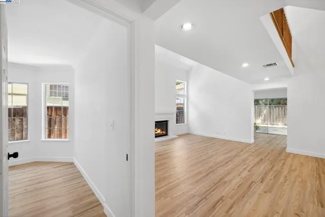 a view of a livingroom with wooden floor and a fireplace