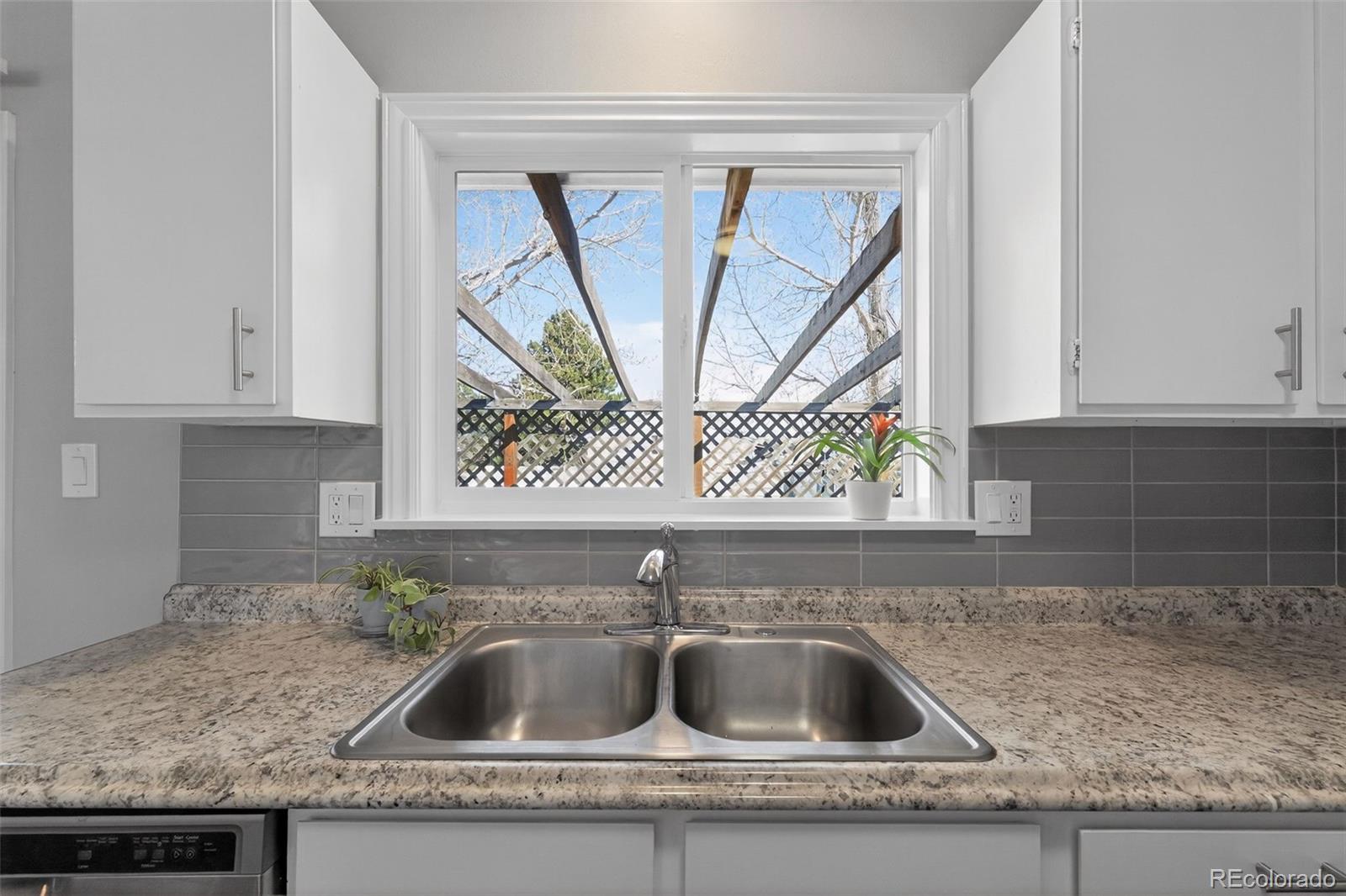 2116 Springfield Court Fort Collins, CO 80521 - Photo 17 of 29 a kitchen sink with a granite countertop white cabinets and sink
