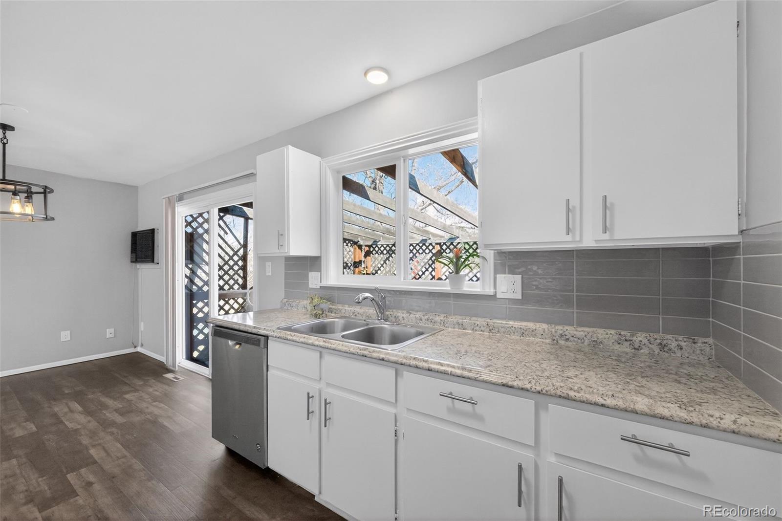 2116 Springfield Court Fort Collins, CO 80521 - Photo 18 of 29 a kitchen with stainless steel appliances granite countertop white cabinets and window