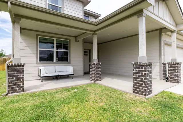 a kitchen with stainless steel appliances a dining table chairs refrigerator and microwave