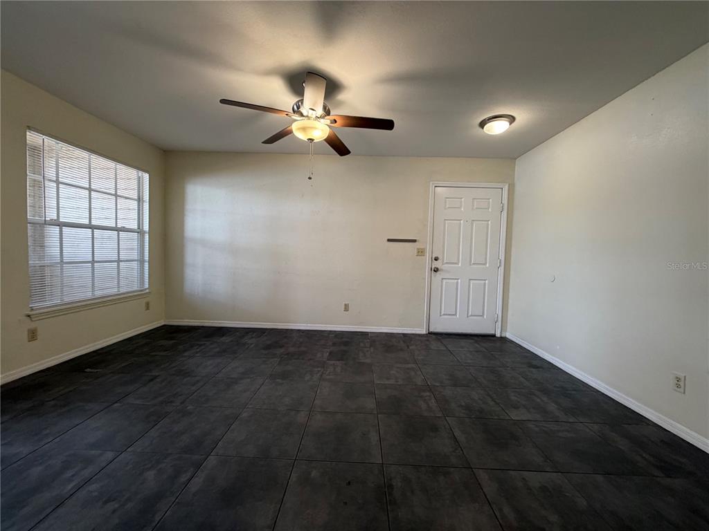 1071 South Hiawassee Road, Unit 1214 Orlando, FL 32835 - Photo 2 of 17 an empty room with wooden floor fan and windows