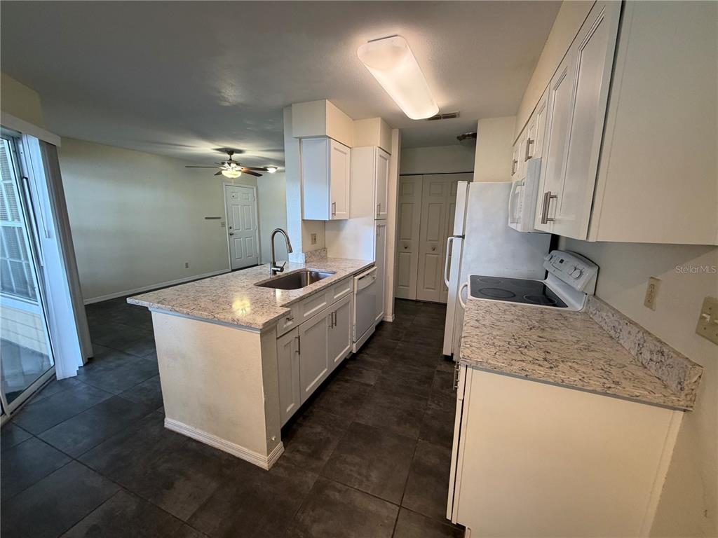 1071 South Hiawassee Road, Unit 1214 Orlando, FL 32835 - Photo 5 of 17 a kitchen with stainless steel appliances granite countertop a sink stove and refrigerator