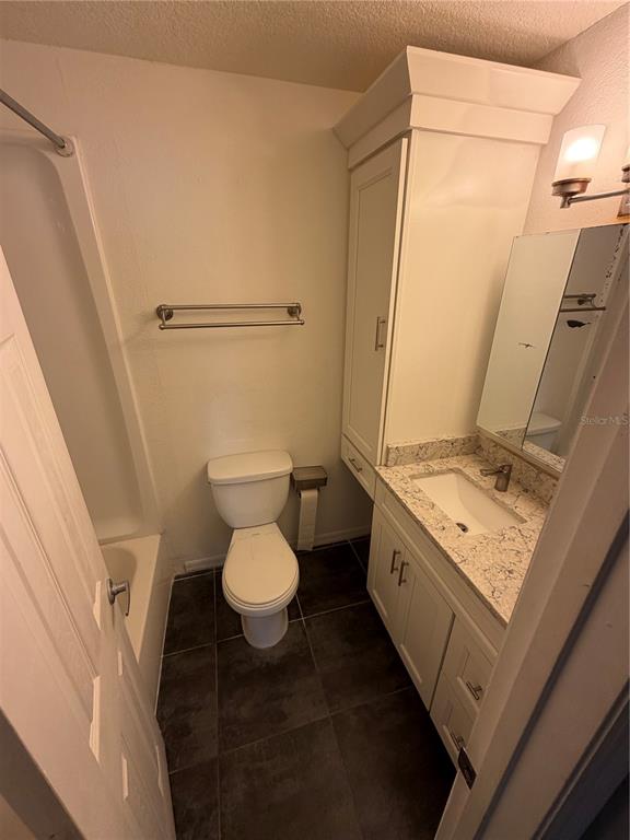 1071 South Hiawassee Road, Unit 1214 Orlando, FL 32835 - Photo 8 of 17 a bathroom with a granite countertop sink toilet and shower