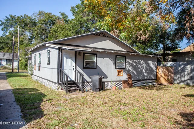 a view of a small house in middle of the yard