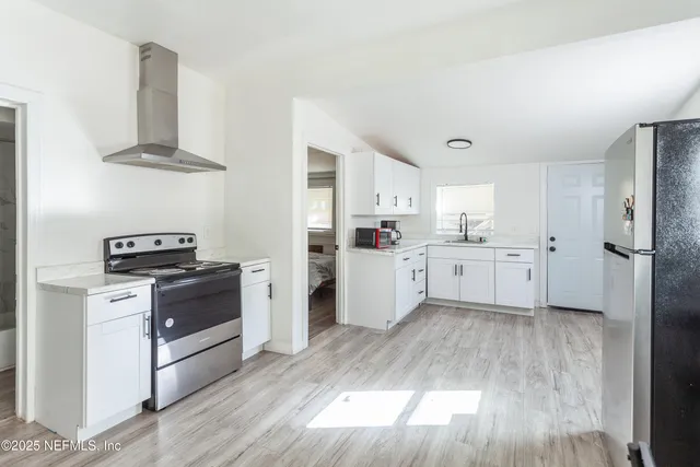 a kitchen with white cabinets and white appliances