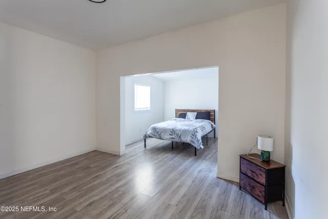 a bedroom with a bed and wooden floor