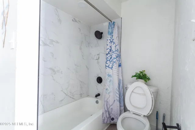 a bathroom with a toilet and a shower