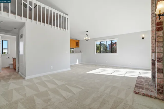 a view of a hallway with wooden floor and a living room