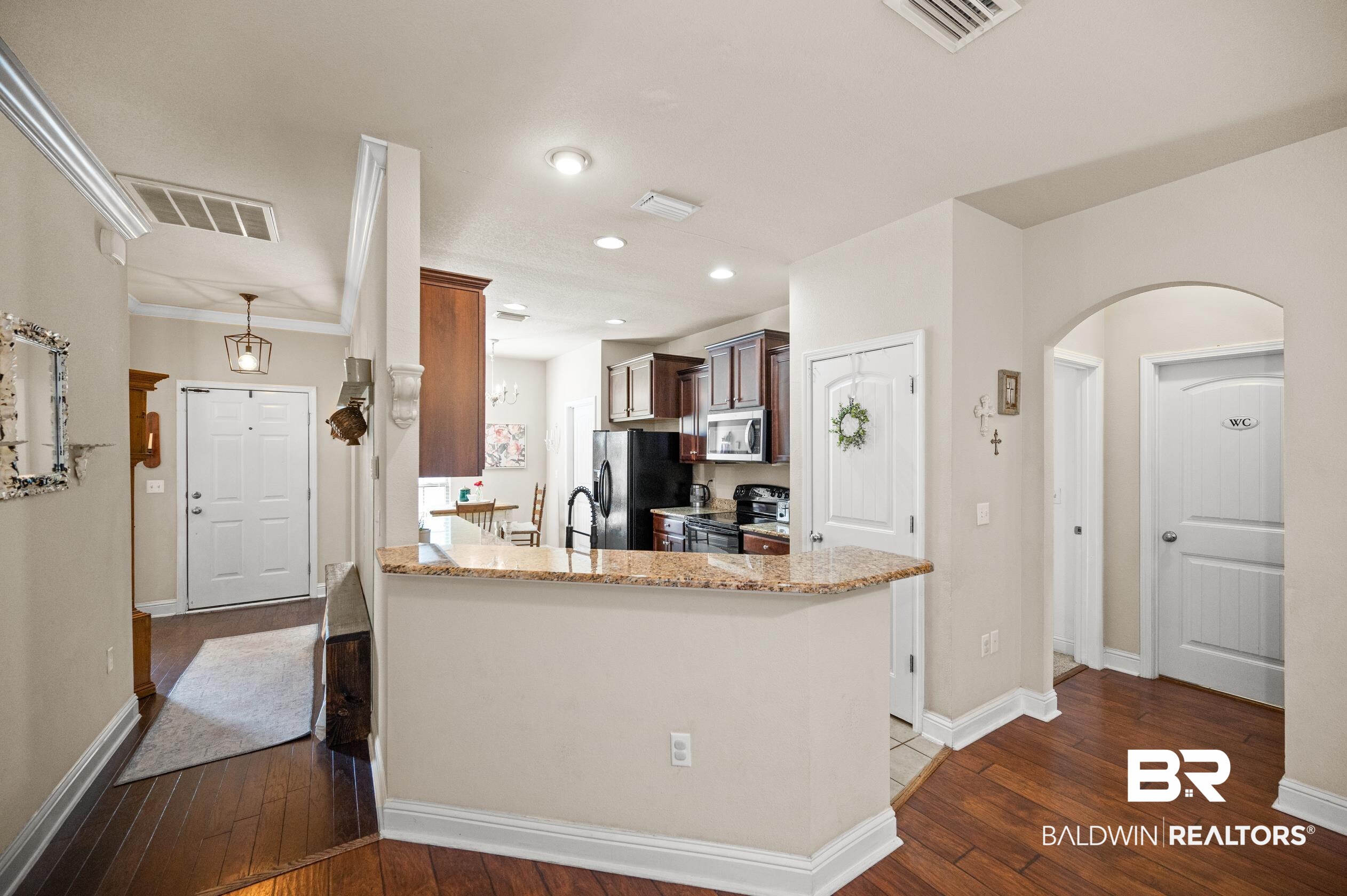 745 Bonaventure Street Fairhope, AL 36532 - Photo 6 of 36 Kitchen with dark hardwood / wood-style floors, black refrigerator with ice dispenser, kitchen peninsula, electric range, and light stone counters