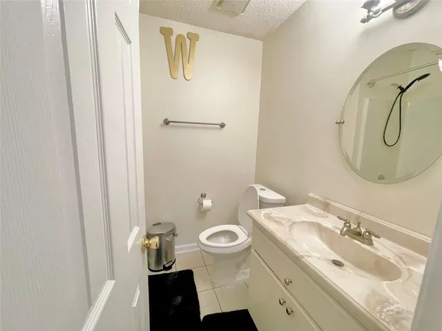 a bathroom with a granite countertop sink toilet and a mirror
