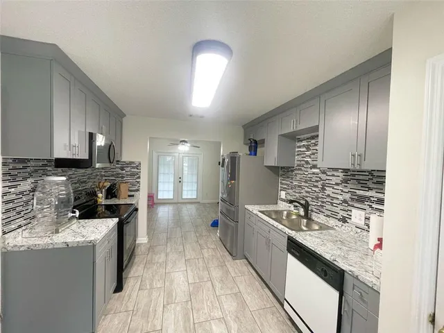 a kitchen with stainless steel appliances granite countertop a sink stove and refrigerator