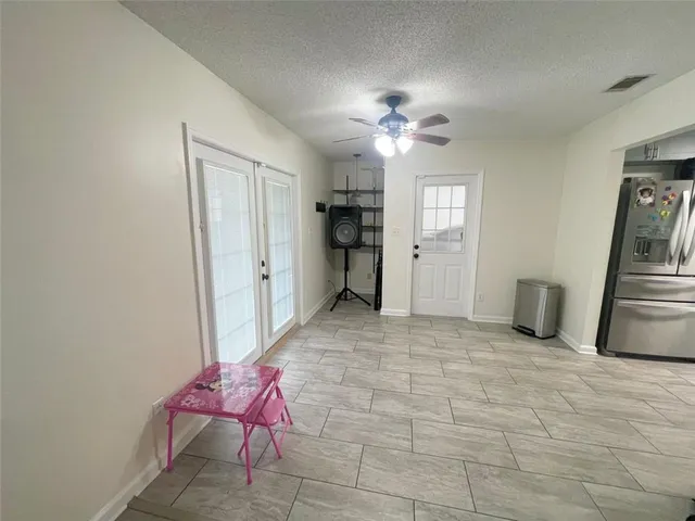 a view of a livingroom with wooden floor and a ceiling fan