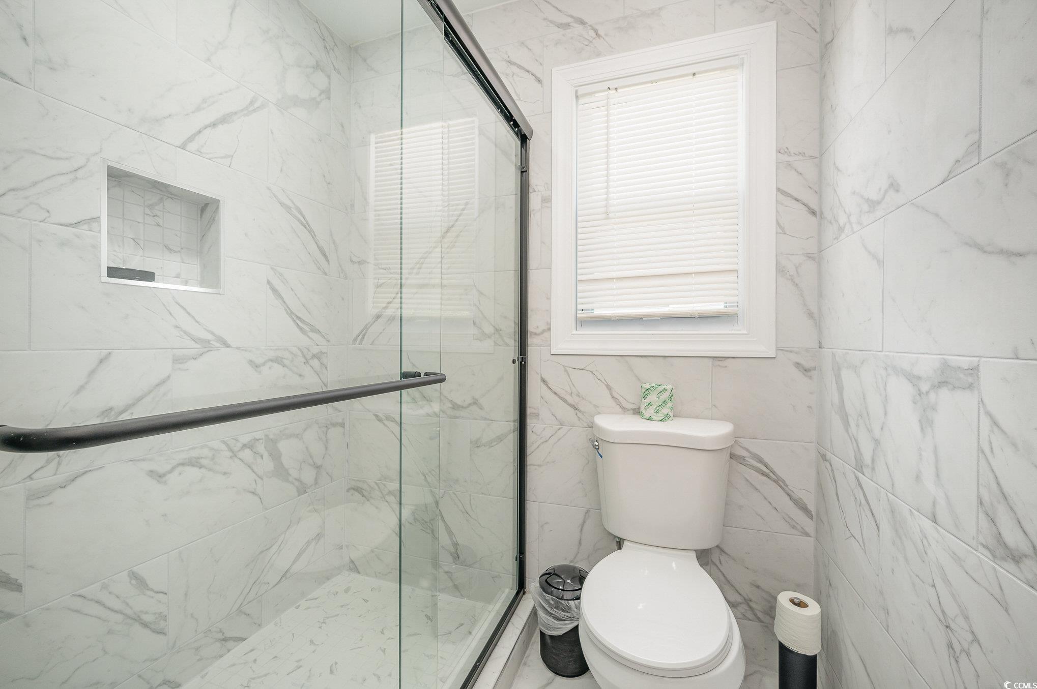 412 27th Avenue North Myrtle Beach, SC 29577 - Photo 18 of 35 Bathroom with a marble finish shower and tile walls