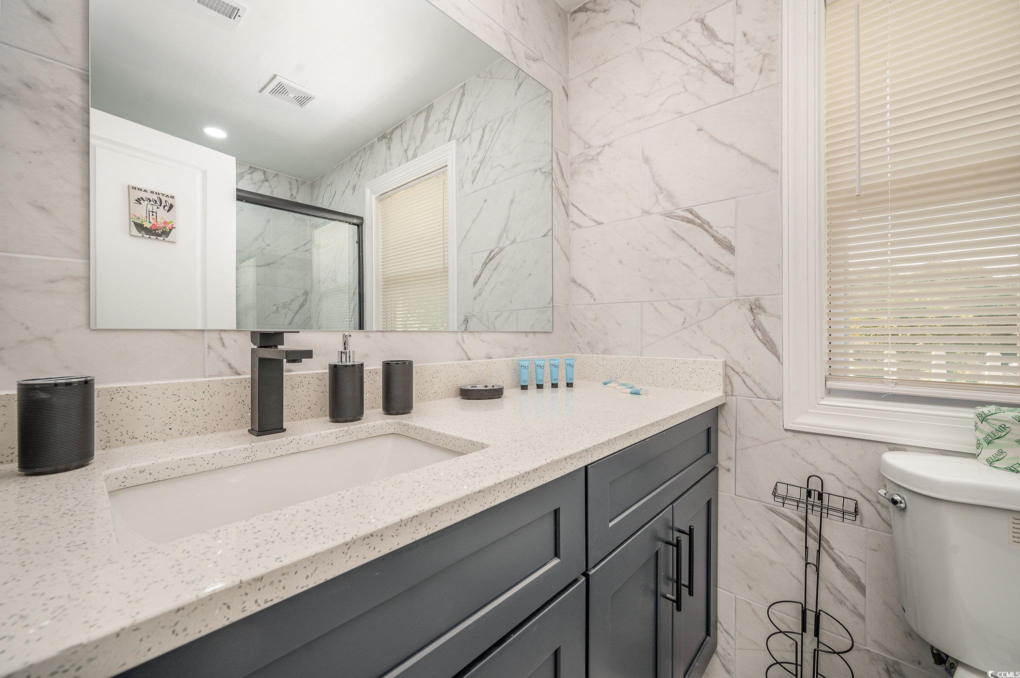 412 27th Avenue North Myrtle Beach, SC 29577 - Photo 19 of 35 Full bath with tile walls, a marble finish shower, and vanity