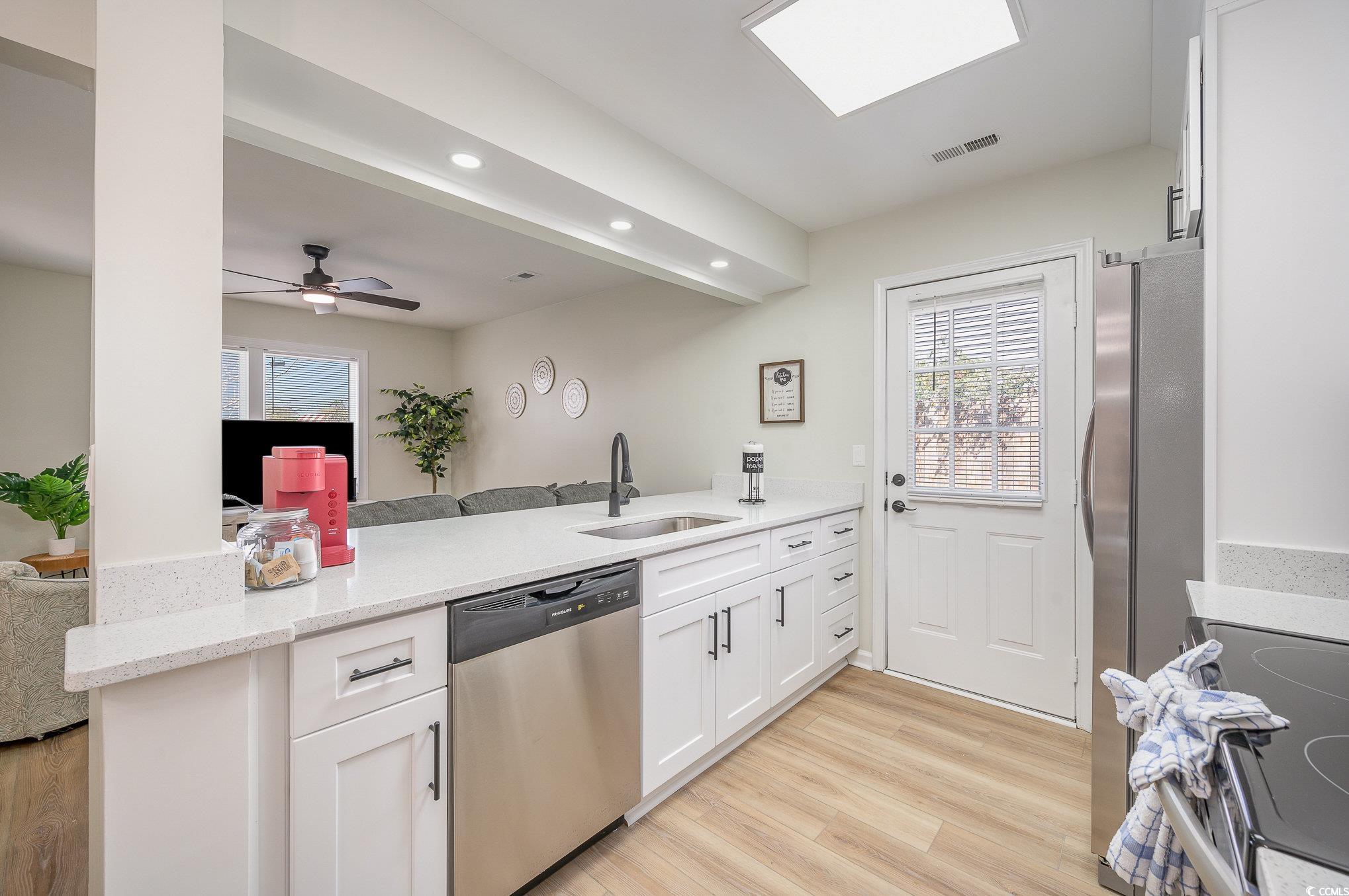 412 27th Avenue North Myrtle Beach, SC 29577 - Photo 35 of 35 Kitchen with stainless steel appliances, light stone countertops, open floor plan, white cabinets, and light wood-style flooring