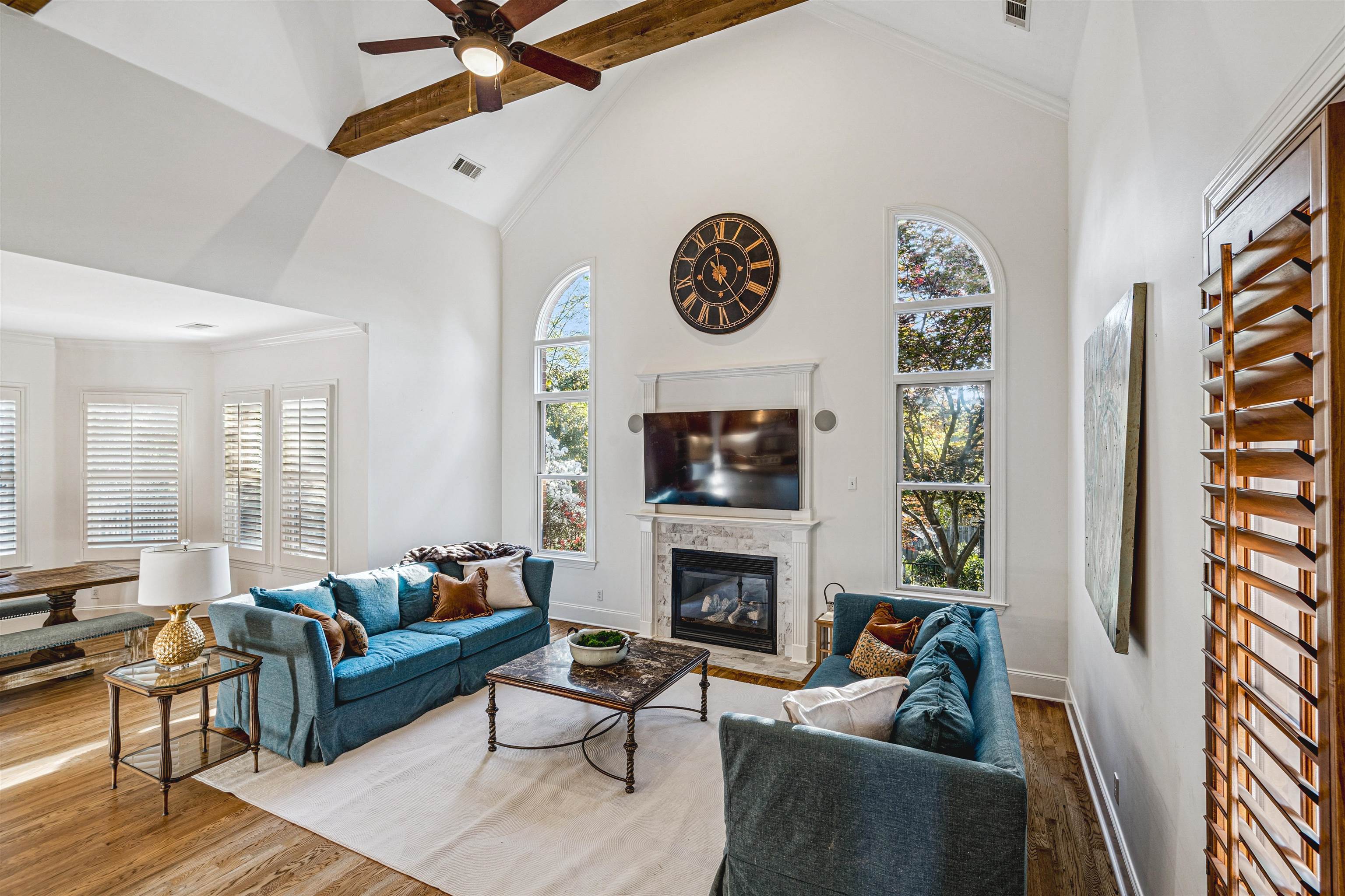 3084 Devonshire Way Germantown, TN 38139 - Photo 13 of 40 Living area featuring a ceiling fan, a glass covered fireplace, ornamental molding, wood finished floors, and a high ceiling