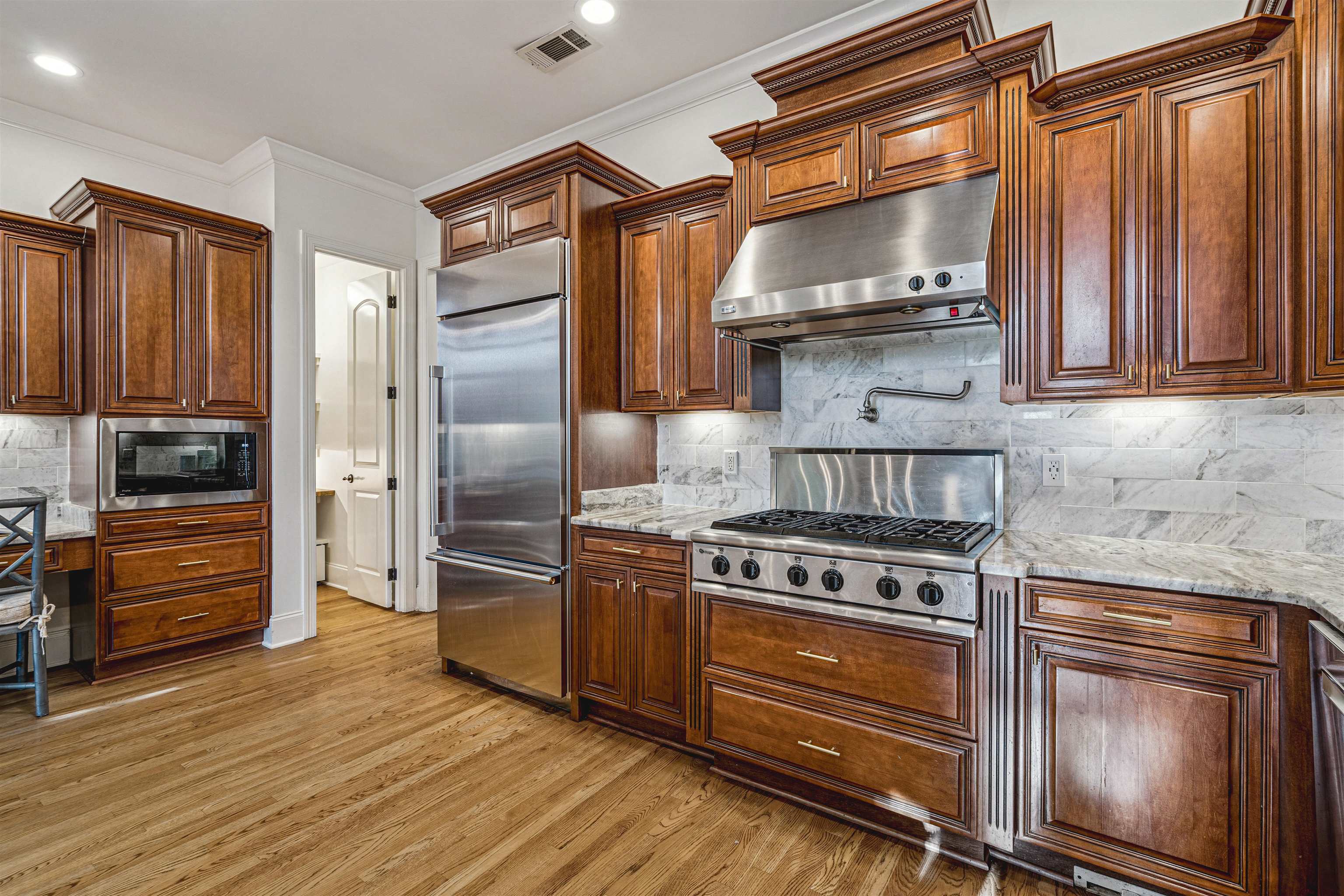 3084 Devonshire Way Germantown, TN 38139 - Photo 17 of 40 Kitchen with built in appliances, light wood-style flooring, light stone counters, crown molding, and recessed lighting