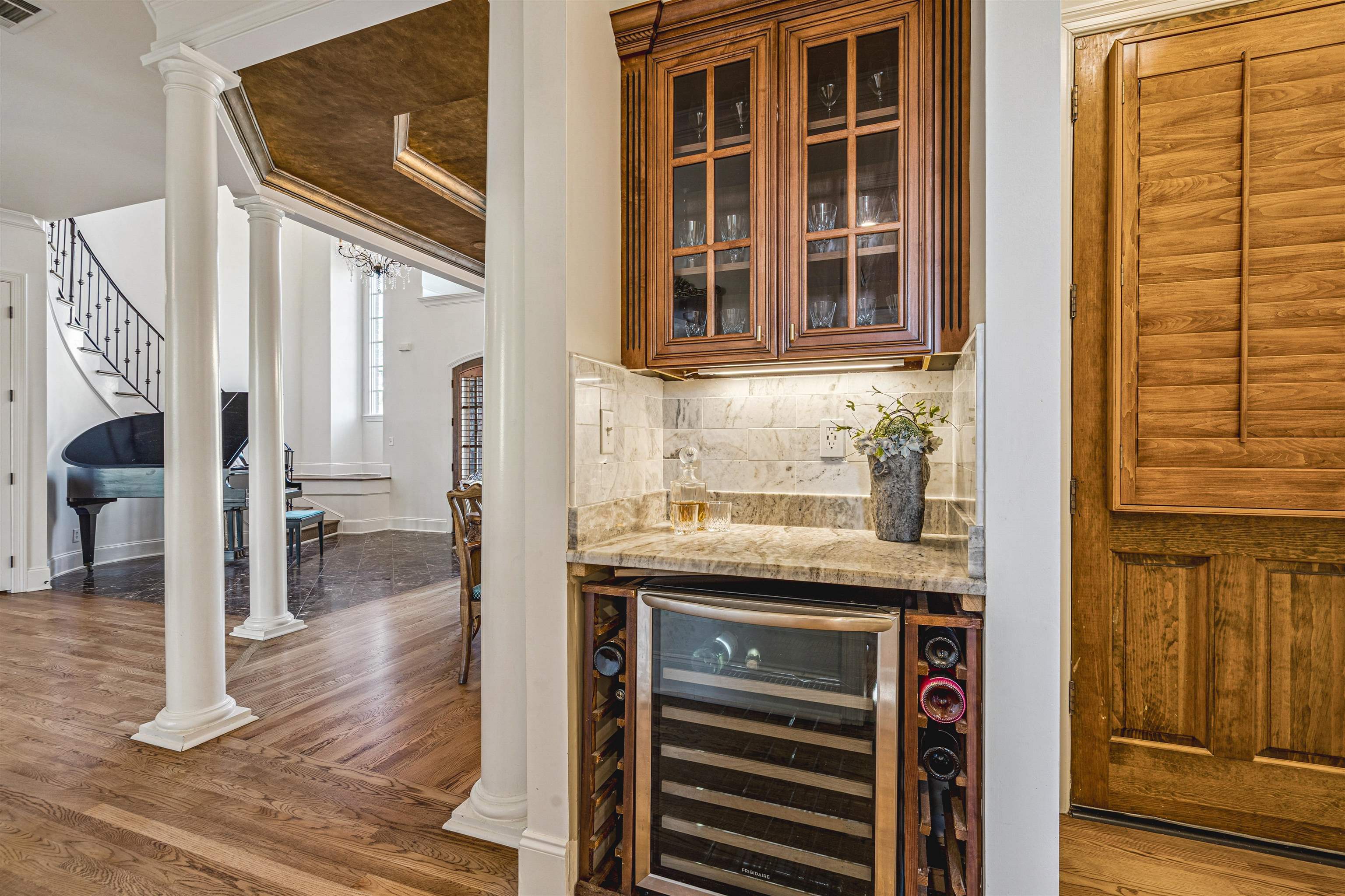 3084 Devonshire Way Germantown, TN 38139 - Photo 18 of 40 Bar featuring ornate columns, wine cooler, glass insert cabinets, light stone countertops, and dark wood-style flooring