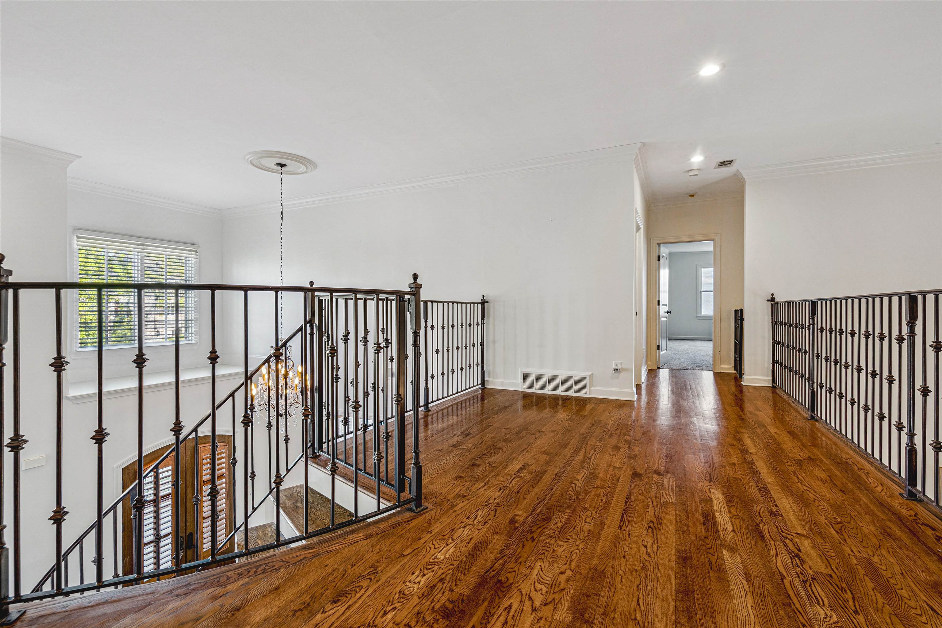 3084 Devonshire Way Germantown, TN 38139 - Photo 23 of 40 Hallway featuring ornamental molding, dark wood-style flooring, an upstairs landing, and a chandelier