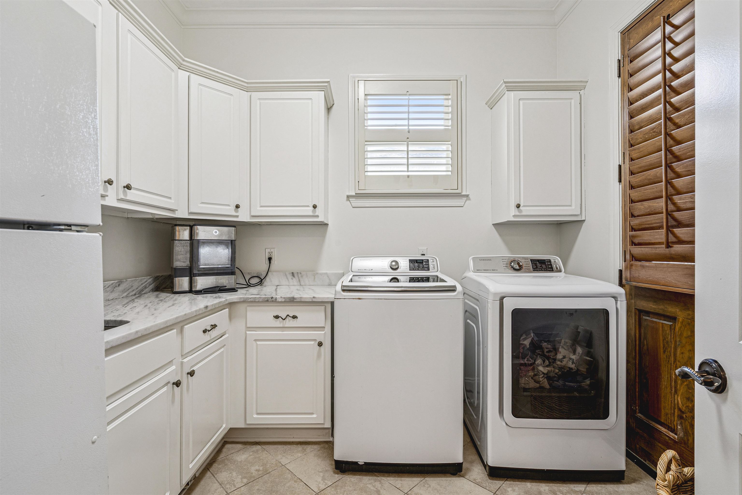 3084 Devonshire Way Germantown, TN 38139 - Photo 32 of 40 Laundry room with washing machine and dryer, crown molding, cabinet space, and light tile patterned flooring