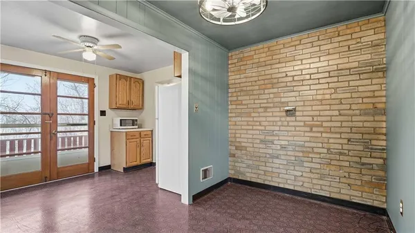 a view of empty room with floor to ceiling window and ceiling fan