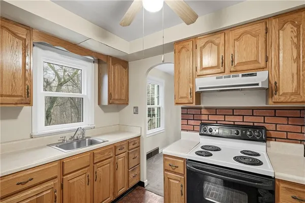 a kitchen with cabinets appliances a sink and a window