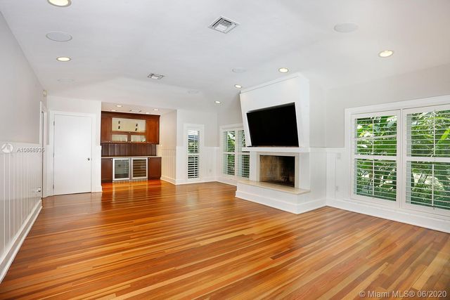 a view of a livingroom with wooden floor and a fireplace
