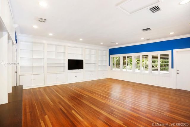 a view of empty room with wooden floor and windows