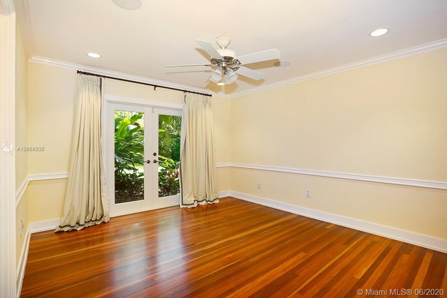 a view of a room with wooden floor fan and windows