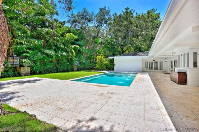 a view of a house with a yard and potted plants