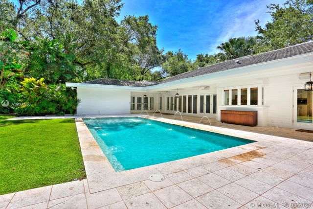 a view of backyard with swimming pool and green space