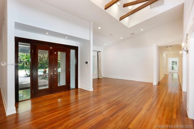 a view of a big room with wooden floor and windows