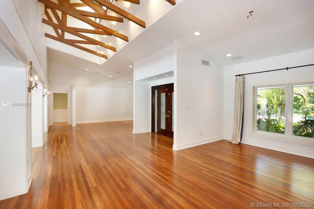 a view of hallway with a large window and wooden floor