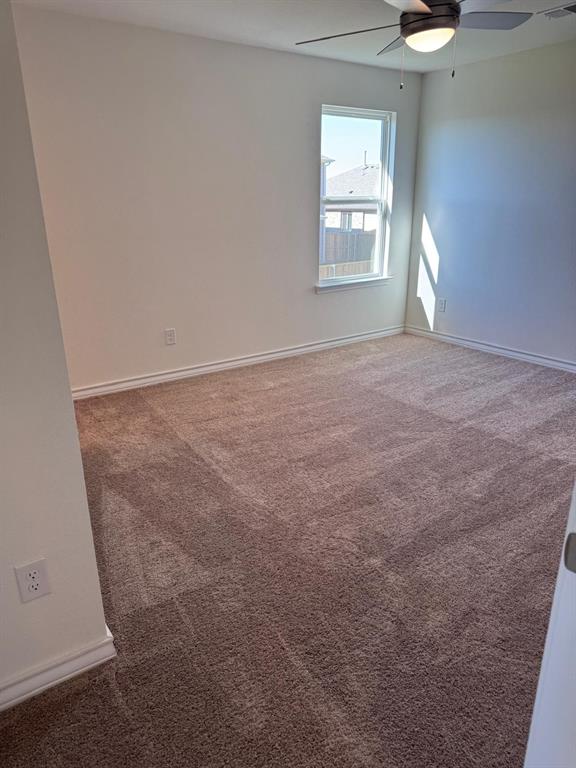 764 Windsor Drive Princeton, TX 75407 - Photo 13 of 18 an empty room with windows and chandelier fan