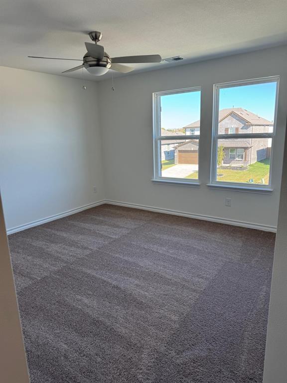 764 Windsor Drive Princeton, TX 75407 - Photo 14 of 18 en empty room with windows and ceiling fan