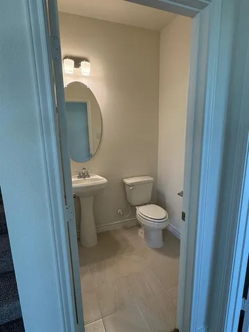 a bathroom with a toilet a sink and a mirror