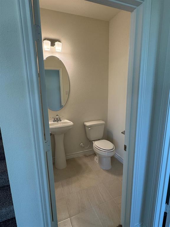764 Windsor Drive Princeton, TX 75407 - Photo 6 of 18 a bathroom with a toilet a sink and a mirror