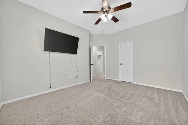 an empty room with fan and windows