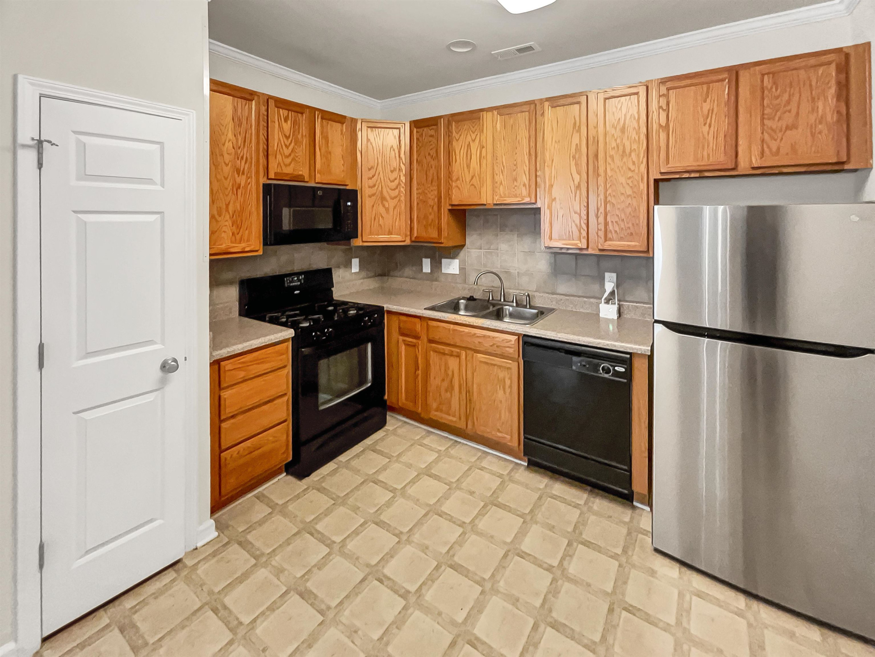 11720 Coppergate Drive, Unit 109 Raleigh, NC 27614 - Photo 4 of 16 a kitchen with stainless steel appliances granite countertop a refrigerator sink and cabinets