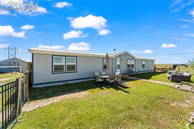 a view of a house with backyard and sitting area