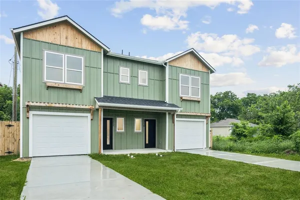a view of a house with yard and garage