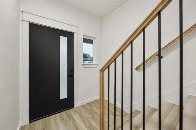 a view of entryway and gallery with wooden floor