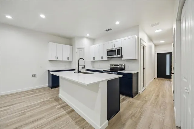 a kitchen with stainless steel appliances granite countertop a sink stove and microwave
