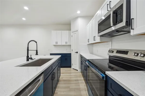 a kitchen with a sink stove and microwave